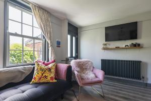 a living room with a couch and a chair and a window at Ace Cottage in Lymington