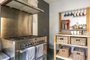 a kitchen with a stainless steel stove and baskets at Ace Cottage in Lymington