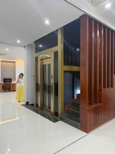 a woman is standing in a lobby with a staircase at Home Me 1 in Dong Hoi