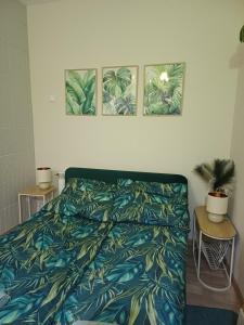 a bedroom with a bed and three pictures on the wall at Rajca Room's - Pokoje przy Jasnej Górze in Częstochowa