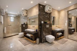a large bathroom with two sinks and two toilets at Corporate Terminal Stay By Velocity Hotels Delhi IGI Airport Terminal 3 With Free Airport Pickup in New Delhi +12 photos