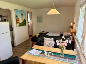 a living room with a couch and a table with flowers at Ferienhäuser Vogelsang in Sagard