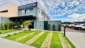 a building with a lawn in front of a parking lot at Nathus Hotel in Chapadão do Sul