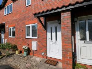 a brick house with a white door and windows at The Gower Gateway in Swansea