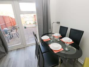 a dining room with a table and chairs and a balcony at The Gower Gateway in Swansea +13 photos