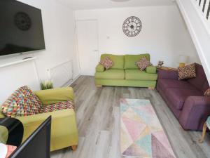 a living room with two couches and a tv at The Gower Gateway in Swansea