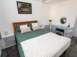 a bedroom with a bed with a desk and a mirror at The Gower Gateway in Swansea