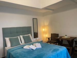 a bedroom with a blue bed with towels on it at Agioi Apostoloi apartments in Agioi Apostoli