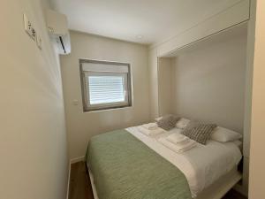 a small bedroom with a bed with two towels on it at O Vilarealense Heritage Apartment in Vila Real