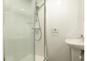 a white bathroom with a shower and a sink at Globeworks by UTDM in Birmingham