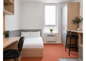a bedroom with a bed and a desk and a window at Globeworks by UTDM in Birmingham