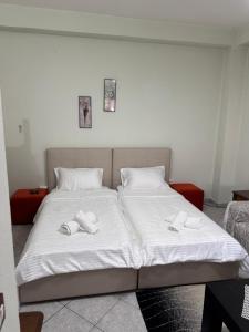 a bed with two white towels on top of it at Bloom House Përmet in Përmet