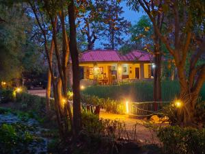 a house with lights in the yard at night at Tiger Trails Resort in Tāla