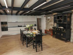 a dining room with a table and a kitchen at Quinta Cerca da Milhera in Ponte da Barca
