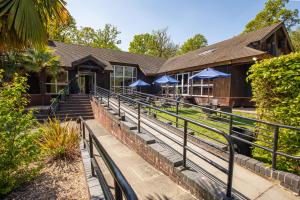 a building with stairs and blue umbrellas at Marwell Hotel Winchester South in Winchester