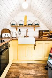 a kitchen with yellow cabinets and a sink at 2 - Luxury Escape - Outdoor bathtub and sauna under the stars! in Pont Sticill