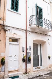 a white building with a door and a balcony at Casa 1941 in Conversano