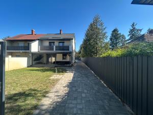 a house with a fence and a driveway at LUX Pool Villa Zamárdi in Zamárdi