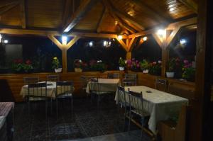 a dining room with tables and chairs and flowers at Pensiunea Alexa in Durău