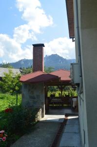 a building with a pavilion with mountains in the background at Pensiunea Alexa in Durău