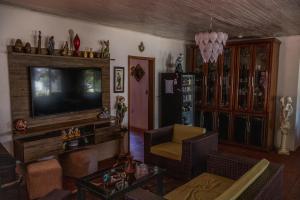 a living room with a television and a couch at Pousada recanto do mar torres Itapeva norte in Torres