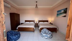 a bedroom with two beds and two ottomans at Spicy Beach Camp in Nuweiba