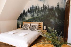 a bedroom with a mountain mural on the wall at Tabakowa Chata in Zawoja
