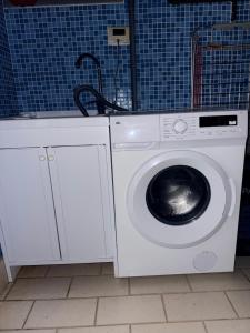 a washing machine in a bathroom with a blue wall at Collina sul Mare Home Cinema 100 Pollici in Ortona
