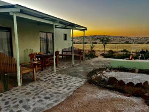 a house with a patio with a table and chairs at Green Elephant Cottages Uis in Uis