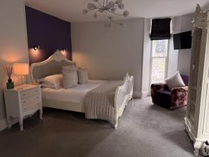 a bedroom with a white bed and a chair at Jacksons CafeBar & Guesthouse in Grasmere