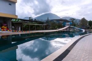 a pool at a resort with mountains in the background at Saung Komando Ciwidey in Winducina