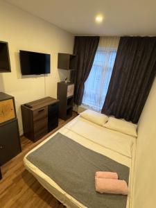 a hotel room with a bed and a television at Pension Ksenija Hanau in Hanau am Main