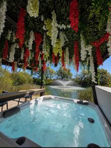 a hot tub with flowers hanging over a pond at Holly Tree Luxury Lodge in Skipwith