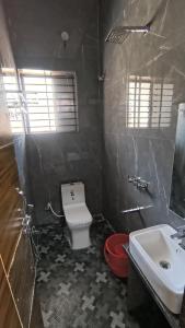 a bathroom with a white toilet and a sink at Hills inn lodge in Hospet