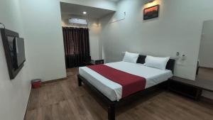 a bedroom with a bed and a television in it at Hills inn lodge in Hospet