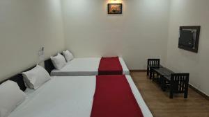 a room with two beds and a bench in it at Hills inn lodge in Hospet