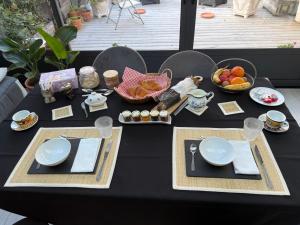 a black table with plates and food on it at Villa les Buissonets in Berck-sur-Mer