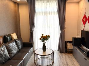 a living room with a couch and a vase of flowers on a table at Sun's house in Phan Rang–Tháp Chàm