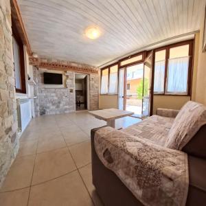 a living room with a couch and a stone wall at Villa Arianna Lake View Apartments with Pool in Tignale