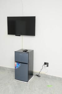 a flat screen tv on a white wall at On Edward in Bulawayo