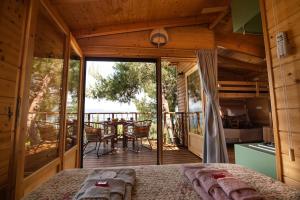 a room with a bed and a balcony with a table at the Treehouse Project in Patra