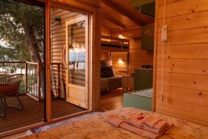a wooden cabin with a balcony with a bed and a kitchen at the Treehouse Project in Patra