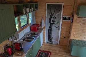 a kitchen with a sink and a tree painting on the door at the Treehouse Project in Patra +23 photos