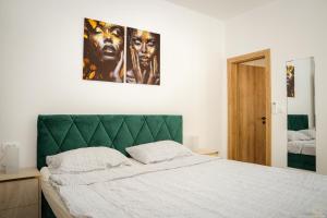 a bedroom with a large bed with a green headboard at Island Pearl in Mali Lošinj