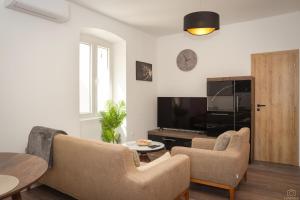 a living room with two chairs and a television at Island Pearl in Mali Lošinj