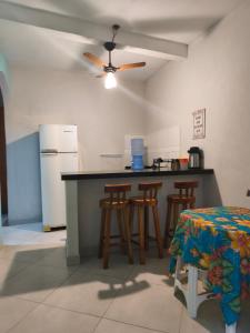 a kitchen with a counter with stools and a refrigerator at Casa da Di in Lençóis
