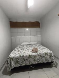 a small bedroom with a bed with a purse on it at Casa da Di in Lençóis +1 photo
