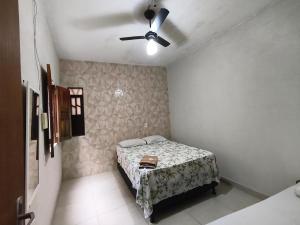 a bedroom with a bed and a ceiling fan at Casa da Di in Lençóis
