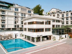 ein Wohnhaus mit einem davorliegenden Swimmingpool in der Unterkunft Qinn Hotels in Antalya