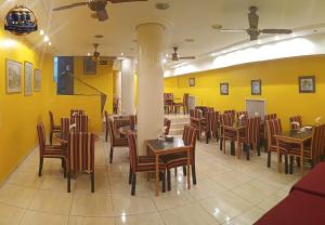 a restaurant with tables and chairs and yellow walls at Hotel Tres Sargentos in Buenos Aires